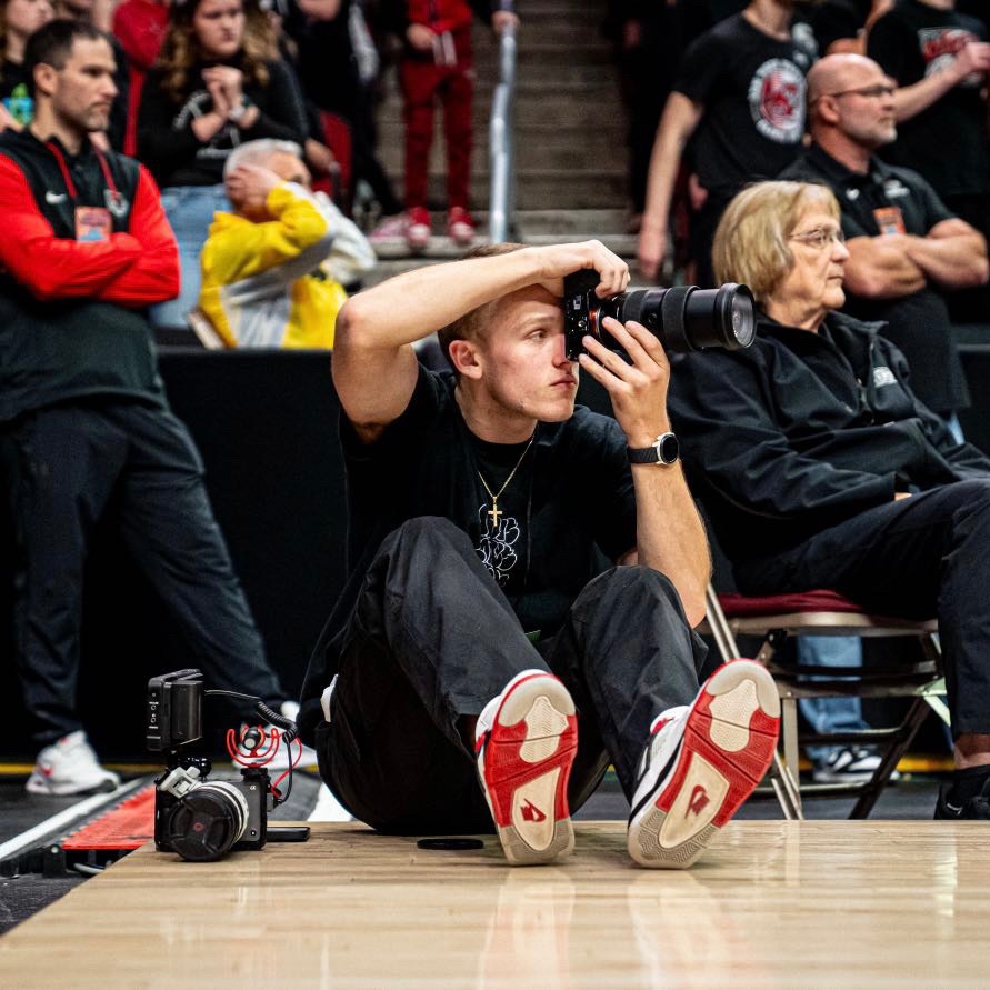joe with hat on filming lady in peach jacket outside
